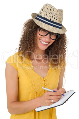 Cheerful young woman writing in notepad