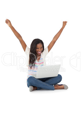 Cheerful young woman with laptop raising hands