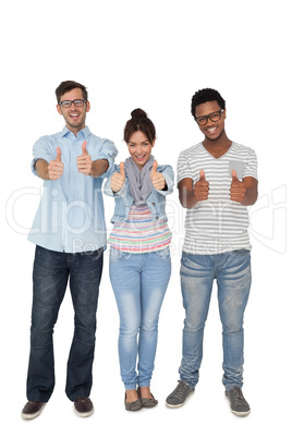 Portrait of three happy friends gesturing thumbs up