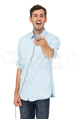 Portrait of a young man holding out microphone