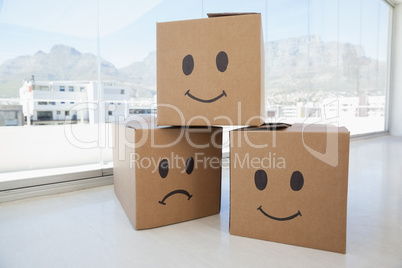 Three cardboard boxes with smiley signs against window