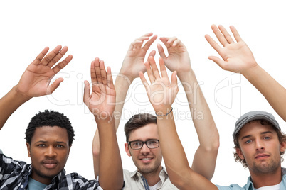 Portrait of three young men raising hands