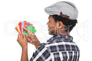 Side view of a young man looking at colorful papers