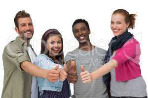 Four happy young friends gesturing thumbs up