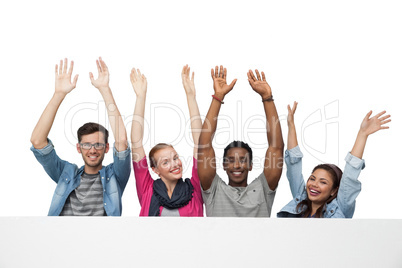 Portrait of four young friends raising hands