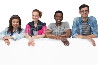 Portrait of happy young friends with blank board