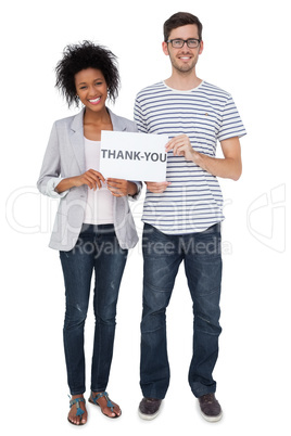 Portrait of a smiling couple holding a thank you note