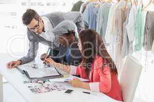 Fashion designers discussing designs in studio