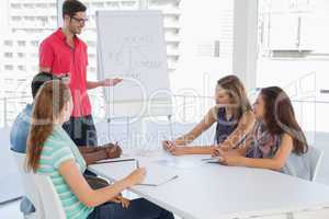 Man giving presentation to casual team in office