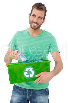 Portrait of a smiling young man carrying recycle container