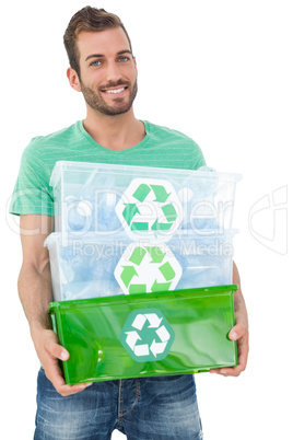Portrait of a smiling young man carrying recycle containers