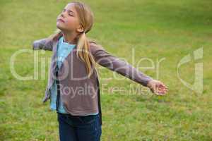 Girl with arms outstretched at park