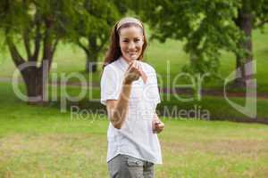 Smiling young woman holding a flower at park