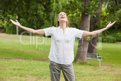 Woman with arms outstretched at park