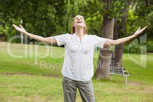Woman with arms outstretched at park