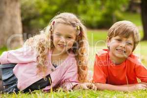 Two smiling kids lying at park