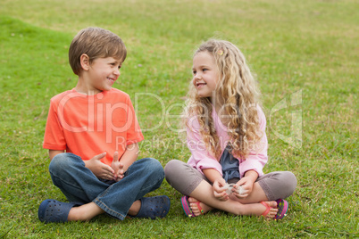 Two smiling kids sitting at park