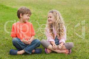 Two smiling kids sitting at park
