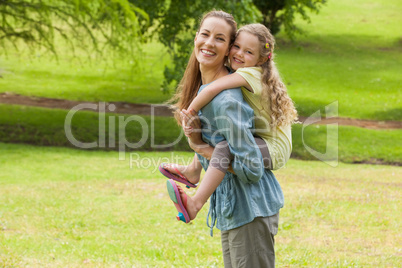 Woman carrying young girl at park Woman carrying young girl at park