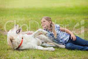 Happy girl playing with pet dog at park
