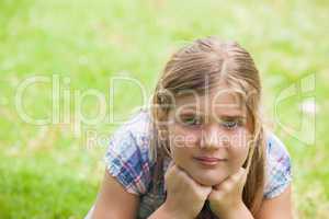 Close-up of a cute girl lying on grass at park