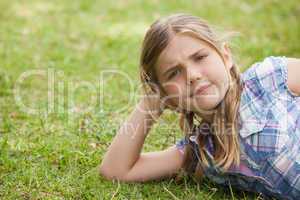 Cute young girl lying on grass at park