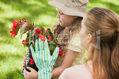 Mother and daughter with a flower pot at park