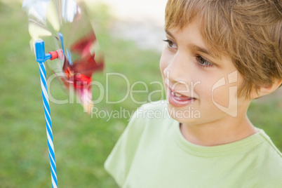 Boy looking at pinwheel in park