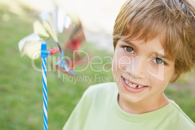 Close-up of smiling boy holding pinwheel in park