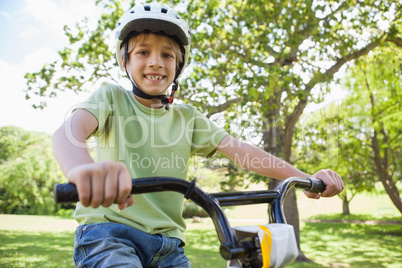 Smiling boy riding bicycle at park