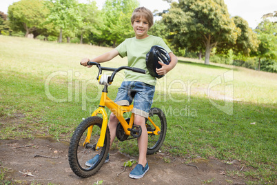 Smiling boy riding bicycle at park