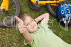 Relaxed boy gesturing thumbs up at park
