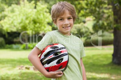 Smiling boy with bicycle helmet at park