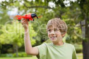 Boy playing with a toy plane at park