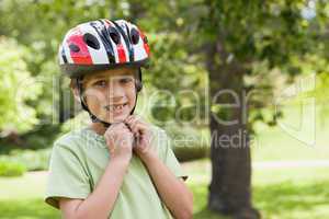 Smiling boy wearing bicycle helmet at park