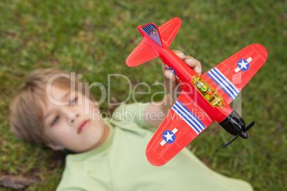 Boy playing with a toy plane at park