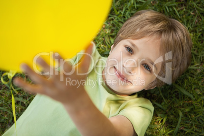 Young boy with yellow balloon at park
