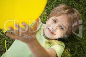 Young boy with yellow balloon at park