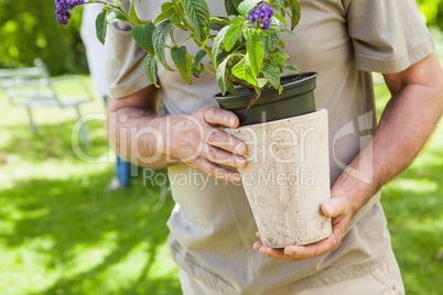 Mid section of a man holding flower pot at park