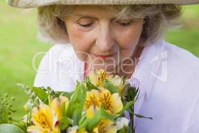 Mature woman smelling flowers at park