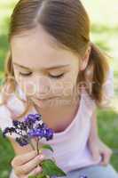 Close-up of girl holding flowers at park