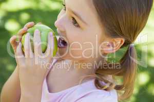 Close-up of a girl eating apple in park