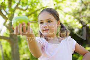 Close-up of girl holding apple in park