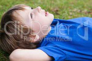 Relaxed young boy lying at park