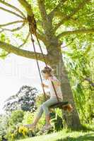 Young girl sitting on swing at park