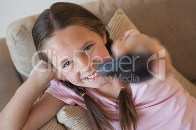 Portrait of a girl changing channels in living room