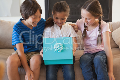 Happy kids with gift box in living room