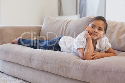 Relaxed young girl lying on sofa