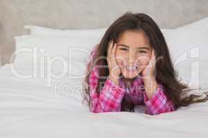 Portrait of a smiling girl lying in bed