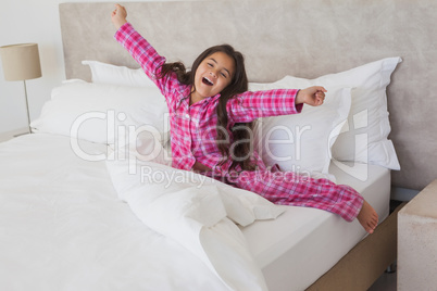 Girl yawning while stretching her arms in bed